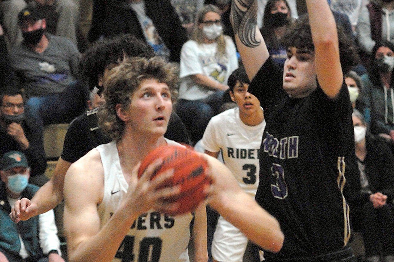 Keith Thorpe/Peninsula Daily News
Port Angeles' John Vaara, left, looks for the hoop as North Kitsap's Aiden Olmstead defends the lane on Thursday night in Port Angeles.