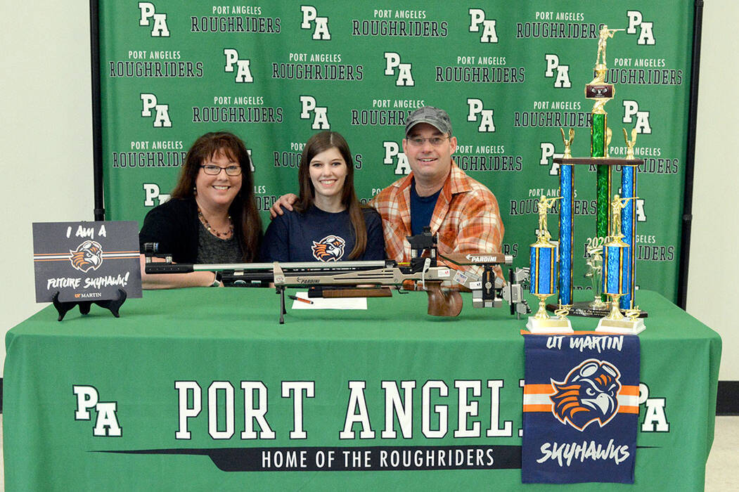 Port Angeles’ Cheyenne Maggard, center, is joined by her parents Meghan and Brent as she signs her letter of intent to compete in air rifle at the University of Tennessee-Martin. (Carmen Geyer/Port Angeles School District)