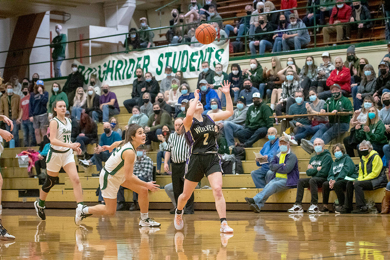 esse Major/For Peninsula Daily News
Port Angeles' Eve Burke, left, and Sequim's Hannah Bates eye a loose ball during the Roughriders' 60-36 Senior Night win over the Wolves.