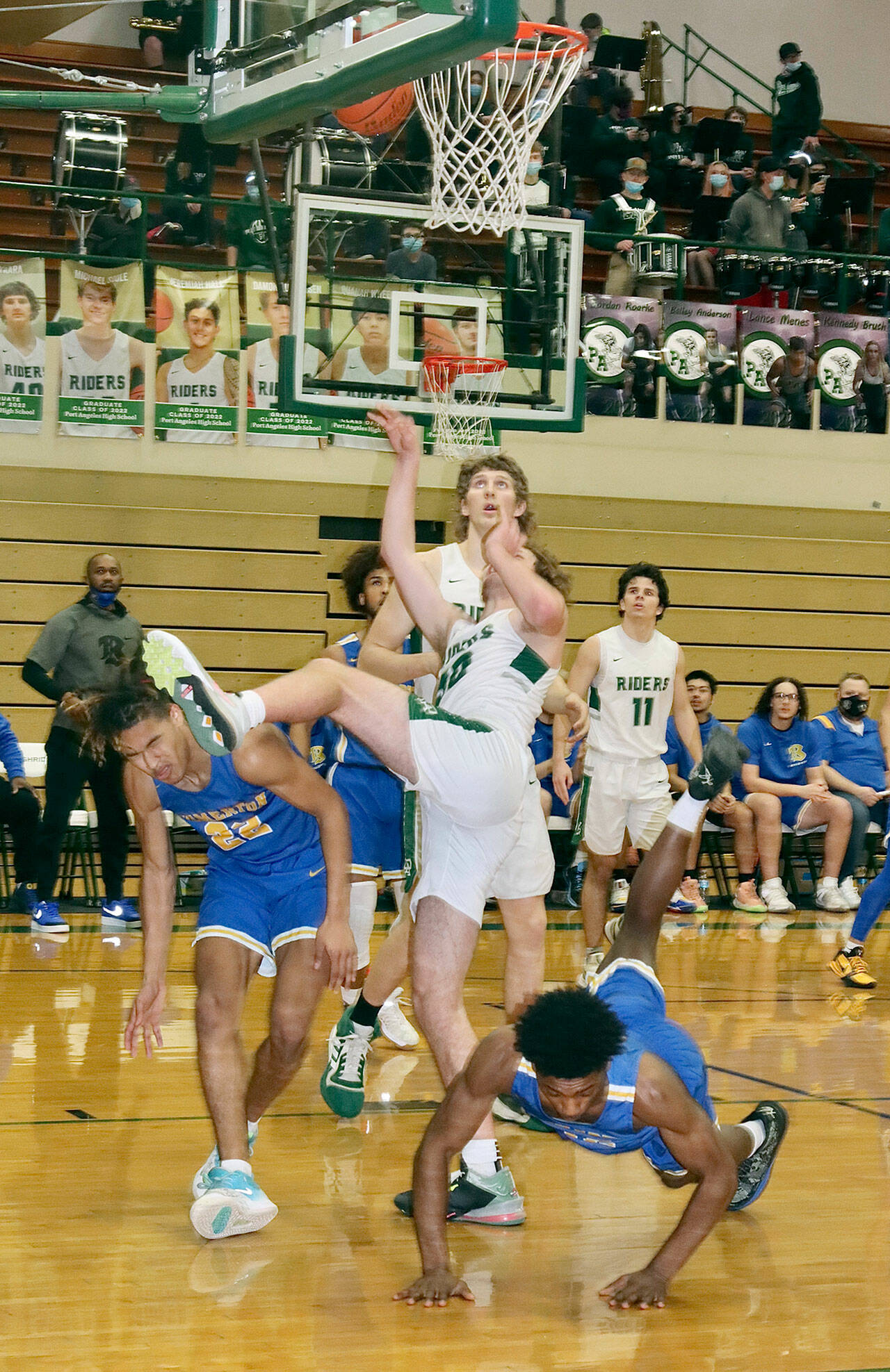 Port Angeles’ Wyatt Dunning has an off-balance shot go in as he parts the Bremerton defense Tuesday night. John Vaara is just behind and Xander Maestas (11) is in the background. (Dave Logan/for Peninsula Daily News)