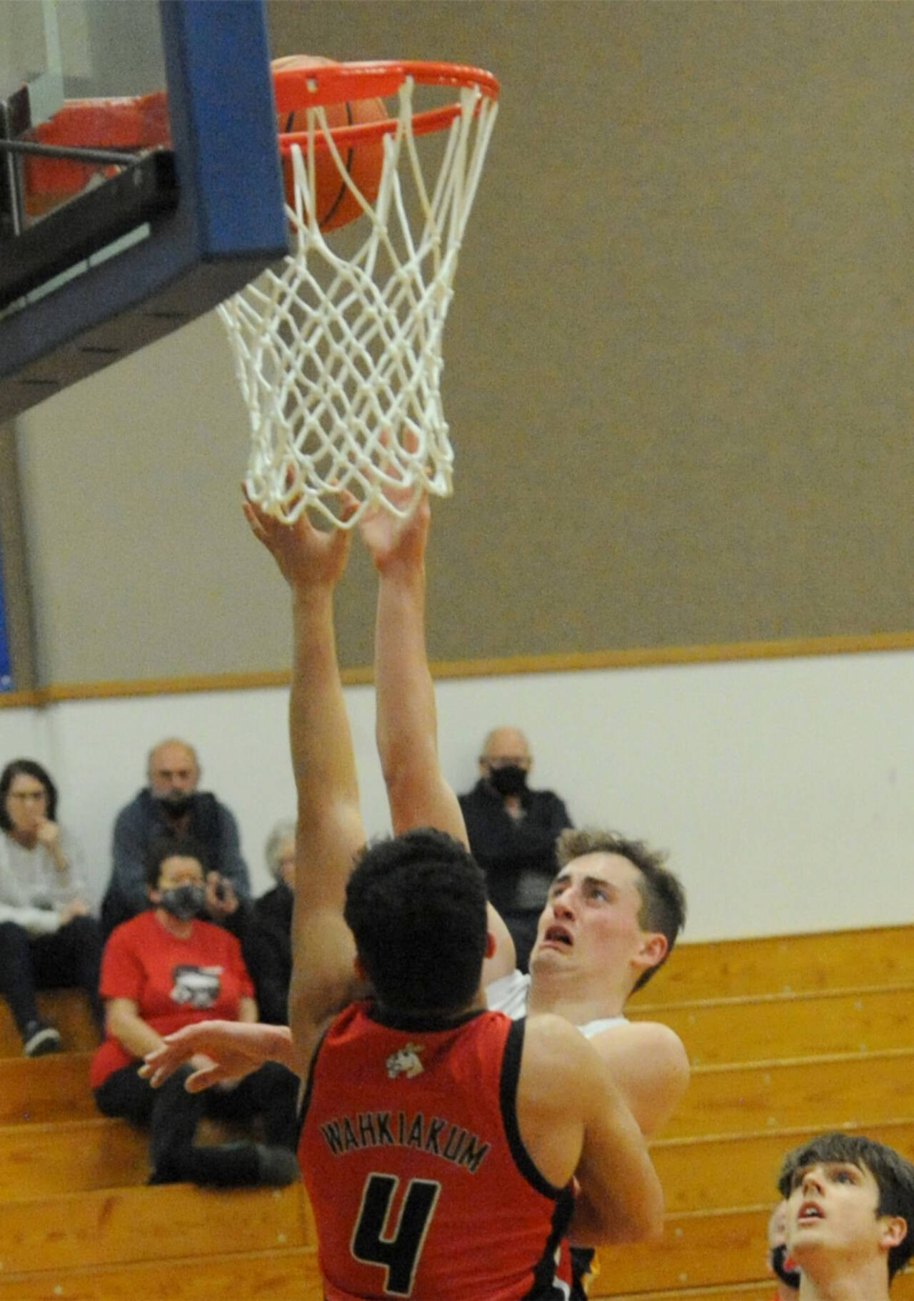 Riley Pursley shoots over Wahkiakum's Dominic Curl (4) on the court at Rochester. Rochester won 65-50, edning the Spartans' season. (Lonnie Archibald/for Peninsula Daily News)