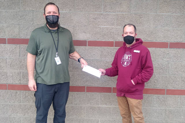 Levi Douglas, left, the center’s Clallam County veteran program director, receives a check from Rod Souza of Jim’s Pharmacy.