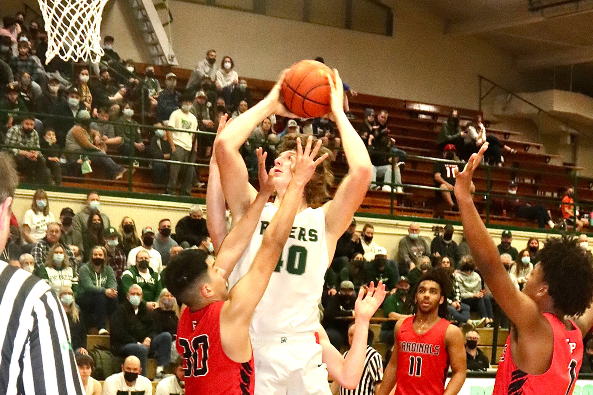 Dave Logan/for Peninsula Daily News
Port Angeles' John Vaara skies over Franklin Pierce's Brandon Herrera during the Roughriders' 68-51 Class 2A District 2/3 tournament victory Wednesday.