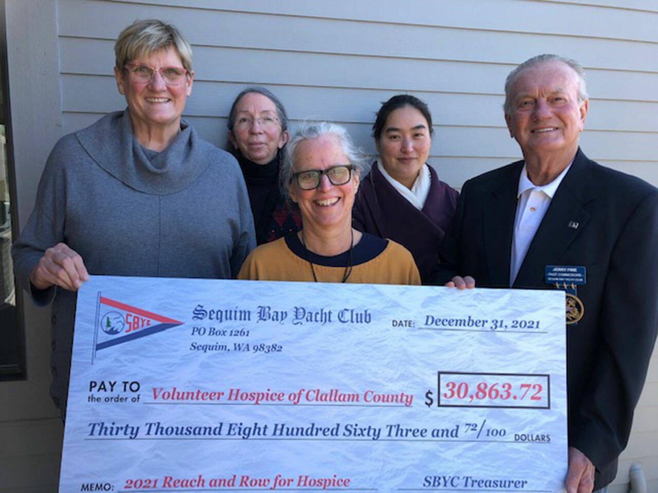 Reach and Row event chair Susan Sorensen, left, presents Sequim Bay Yacht Club donations to Volunteer Hospice of Clallam County Patient Care Coordinator Marca Davies, VHOCC Nurse Team Manager Betsy Wharton and VHOCC Executive Director JooRi Jun along with Jerry Fine, right, 2021 Sequim Bay Yacht Club commodore. (Courtesy photo)