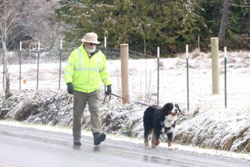 Jon Purnell walks his dog on Hoare Road south of Port Angeles, where the elevation helped to capture some snow. (Dave Logan/for Peninsula Daily News)
