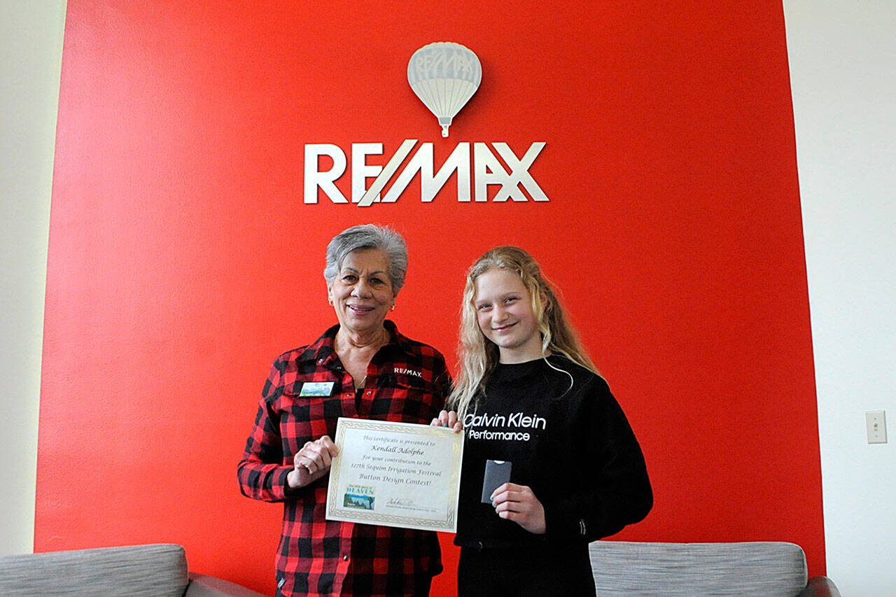 Matthew Nash/Olympic Peninsula News Group
Liz Parks, president of RE/MAX Prime, presents fifth grader Kendall Adolphe with a certificate and gift card for winning the Sequim Irrigation Festival’s button design contest.