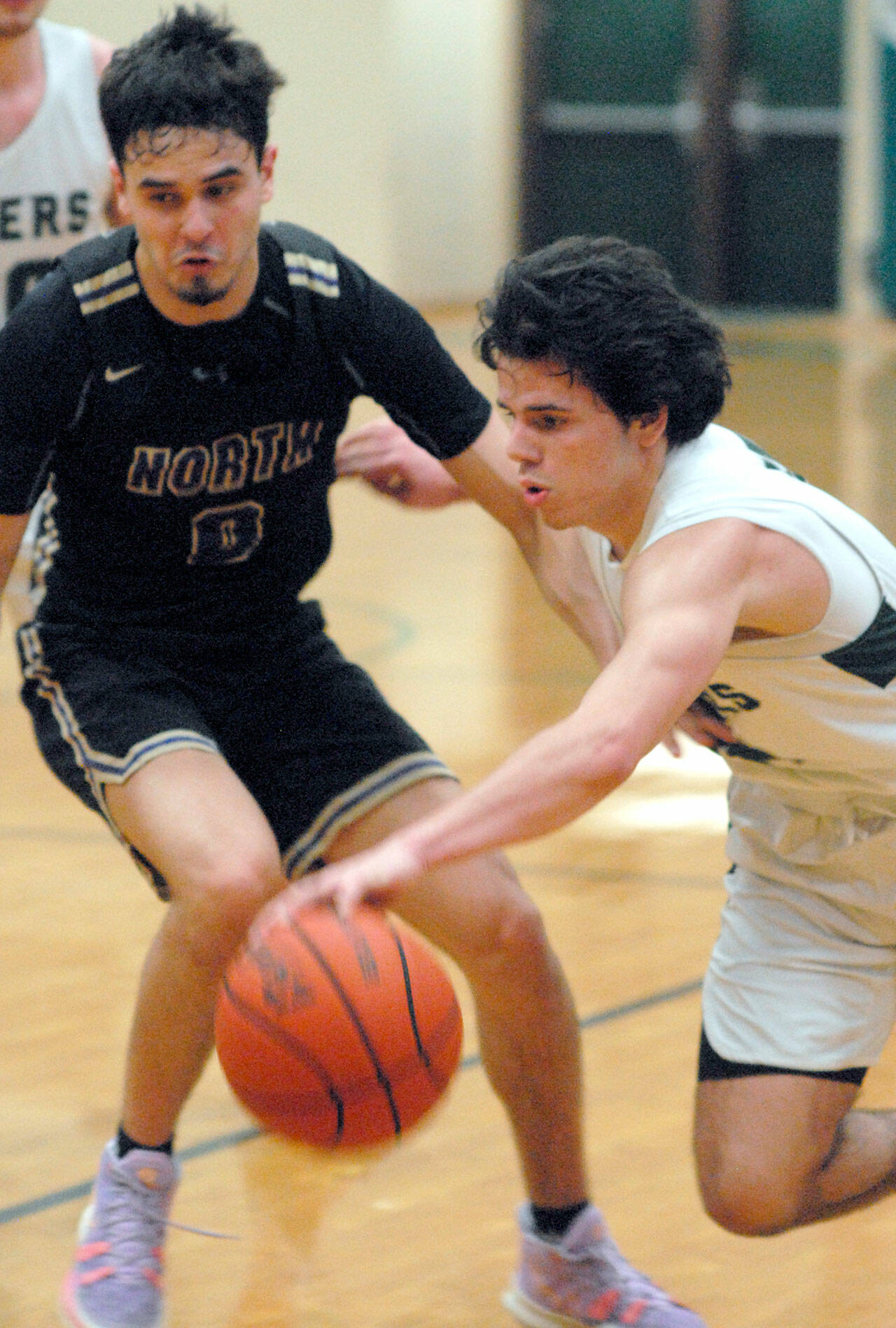 Keith Thorpe/Peninsula Daily News Port Angeles’ Xander Maestas, front, drives past North Kitsap’s Johny Olmsted on Thursday night in Port Angeles.