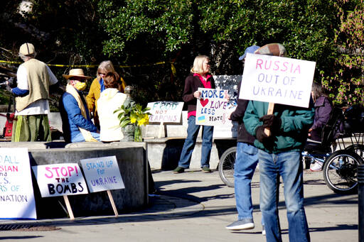 About 25 people gathered at Haller Fountain in Port Townsend on Sunday afternoon to call for peace in Ukraine, Russia and the world. Holding signs and the Ukrainian flag colors, they chanted, “Peace and harmony for the world and ourselves.” (Phil Lusk/For Peninsula Daily News)