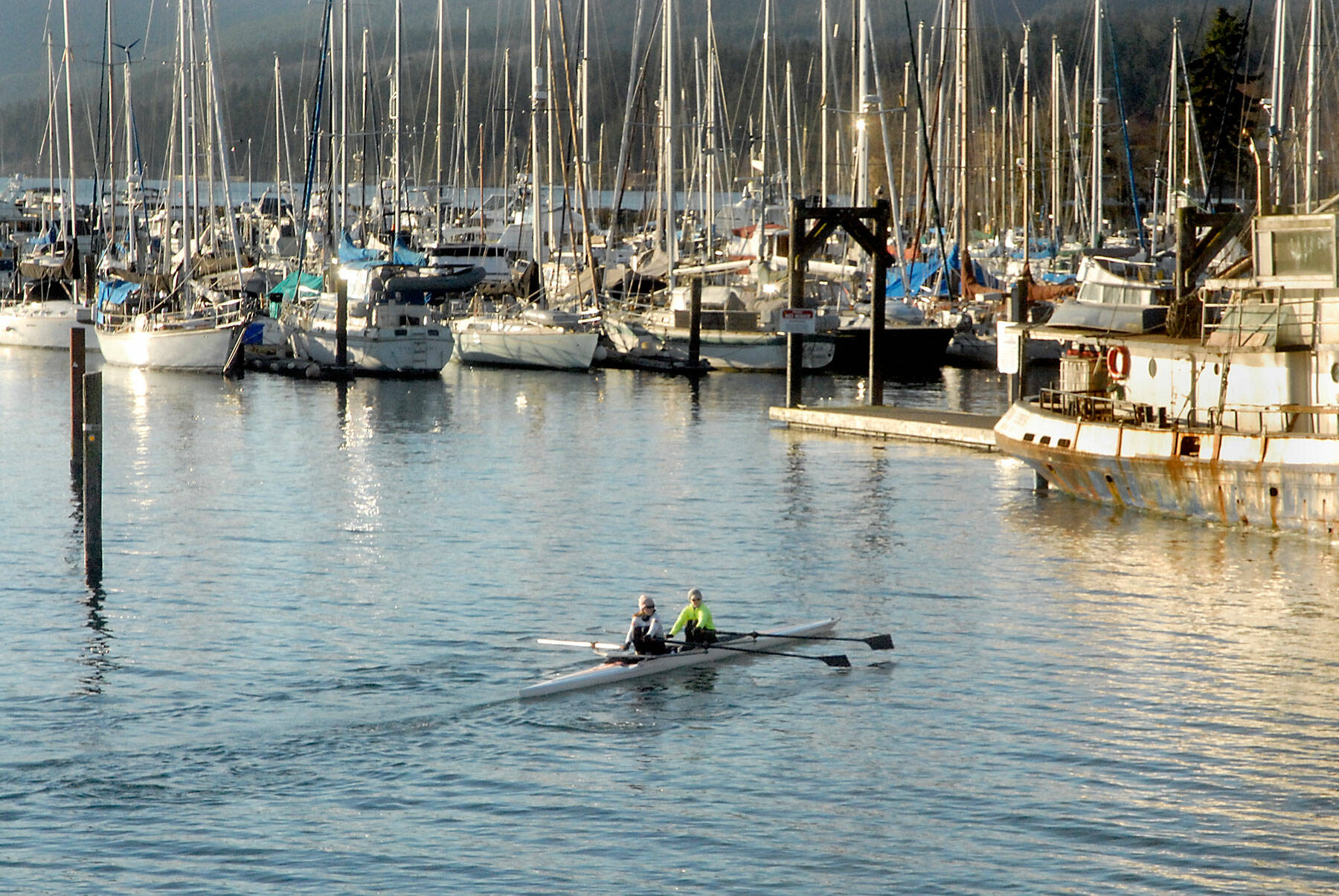 Karlena Brailey, left, and Becky Godby, both of Sequim, paddle into John Wayne Marina near Sequim on Wednesday after rowing on the waters of Sequim Bay. The pair said it was a pleasant morning for rowing in a double scull. (Keith Thorpe/Peninsula Daily News)