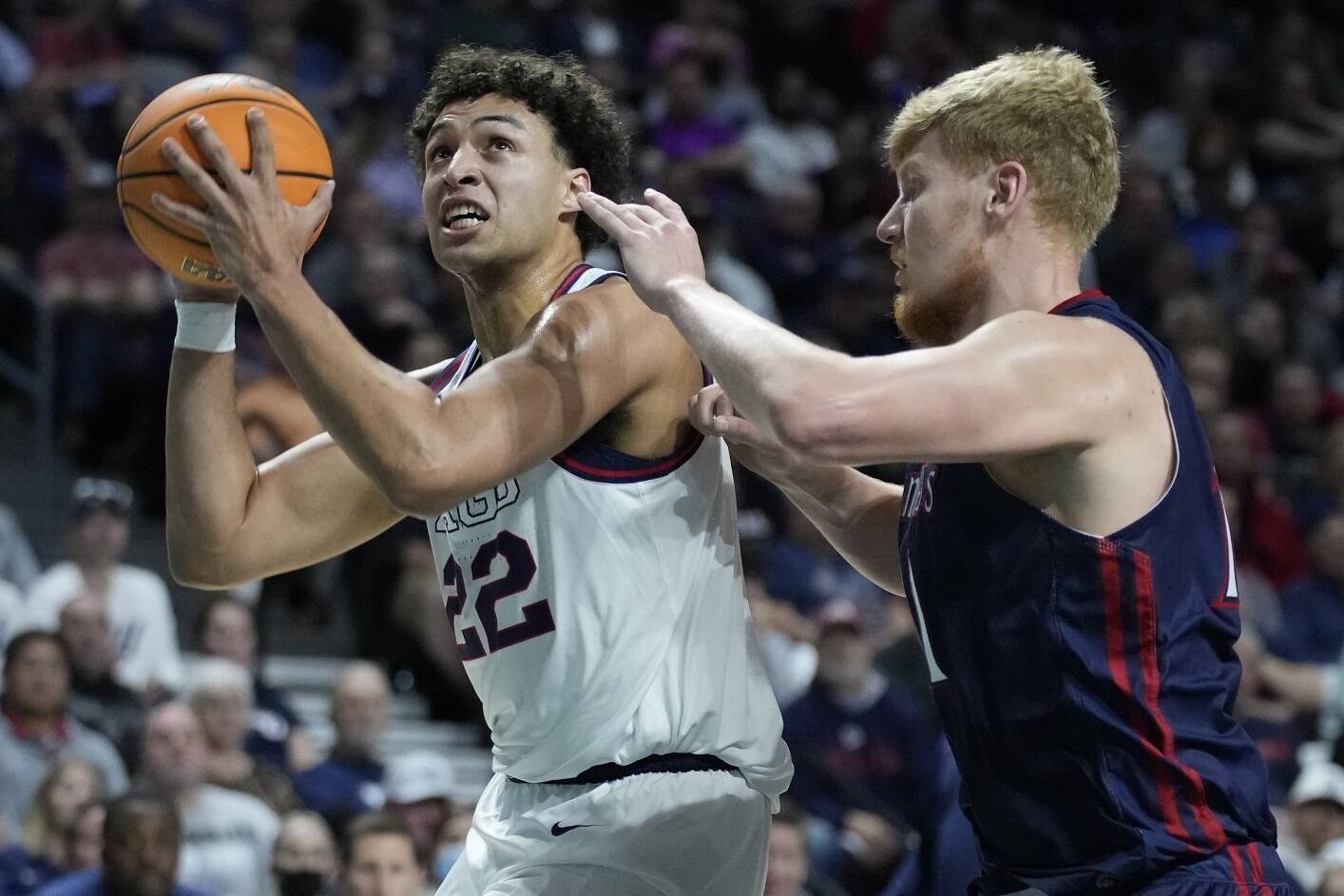 Gonzaga's Anton Watson (22) shoots around Saint Mary's Matthias Tass (11) during the first half of an NCAA college basketball championship game at the West Coast Conference tournament Tuesday, March 8, 2022, in Las Vegas. (AP Photo/John Locher)