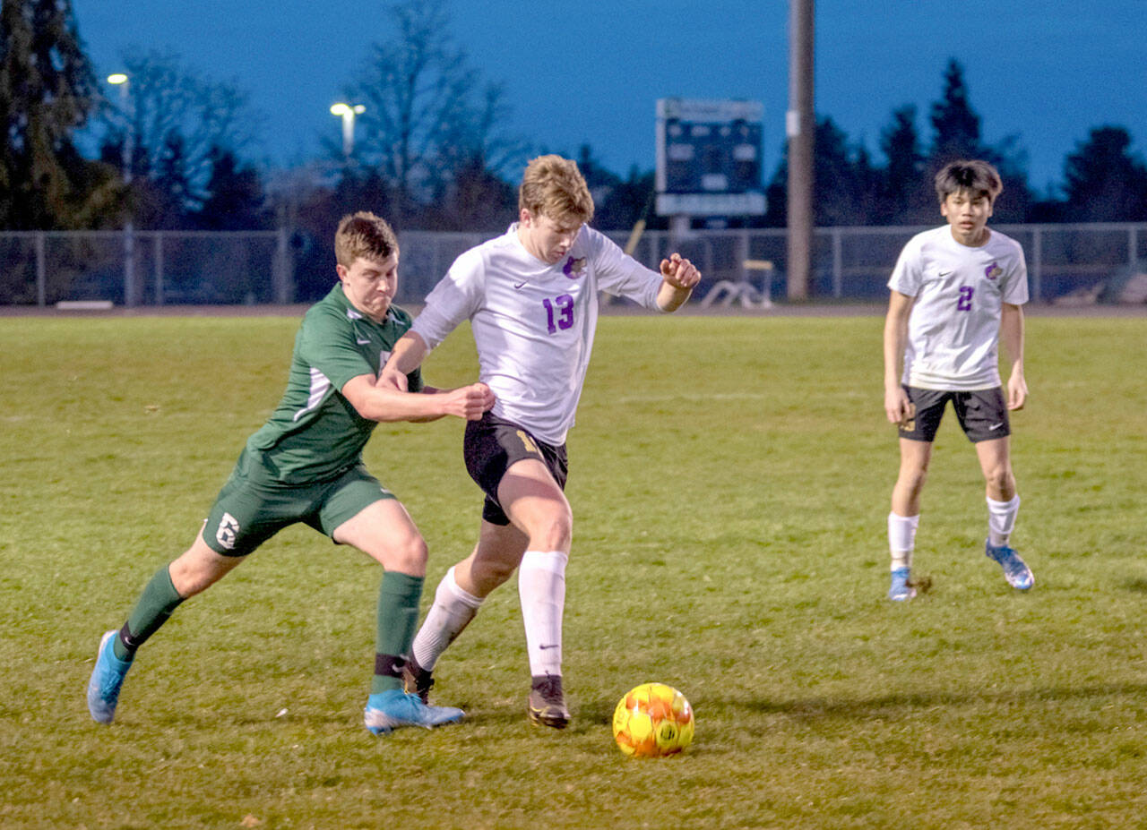 Emily Matthiessen/Olympic Peninsula News Group Sequim’s Brandon Charters fights off Port Angeles’ Caleb McLarty for possession as the Wolves’ Kristian Mingoy looks on during Sequim’s rivalry victory over the Roughriders.