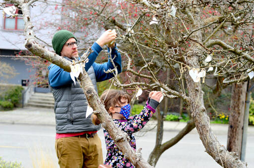 Matt Cooper and daughter Molly, 6, attach their wish slips Sunday afternoon onto the Port Townsend Library’s wishtree, which will be accepting wishes through March 31. The biodegradable, seed-impregnated slips are available inside the library, which is open Tuesdays through Sundays. (Diane Urbani de la Paz/Peninsula Daily News)