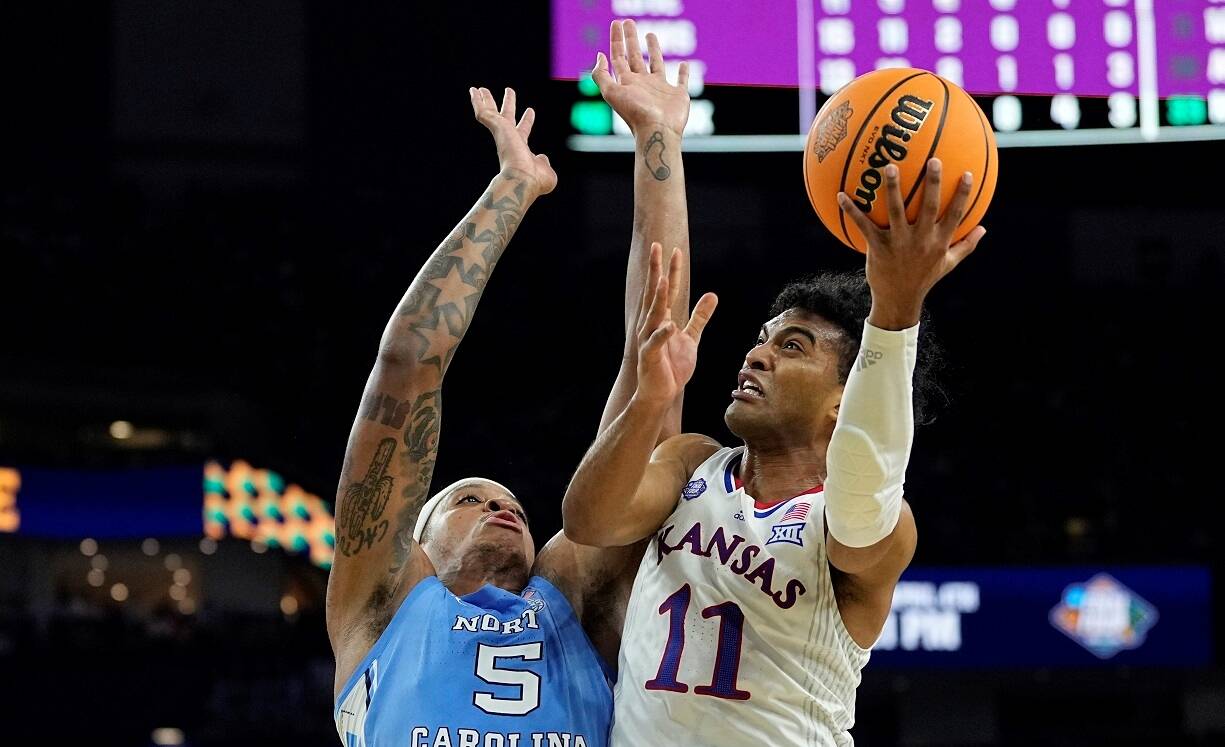 Kansas guard Remy Martin shoots around North Carolina forward Armando Bacot during the second half of a college basketball game in the finals of the Men's Final Four NCAA tournament, Monday, April 4, 2022, in New Orleans. (AP Photo/David J. Phillip)