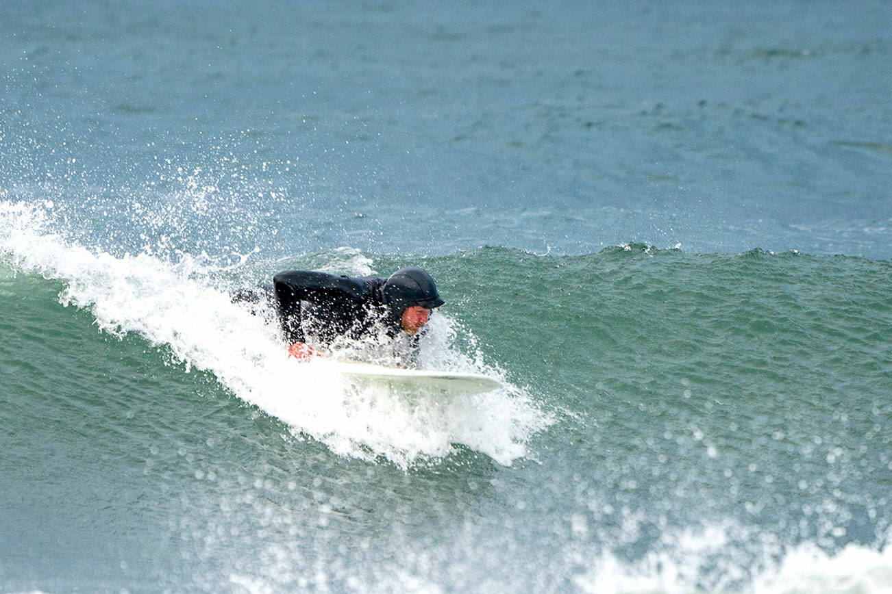 Steve Mullensky/for Peninsula Daily News

A surfer starts to get up on his board to catch a nice 5 foot wave that was formed by high winds and tide at Port Townsend’s Point Hudson beach on Monday morning.