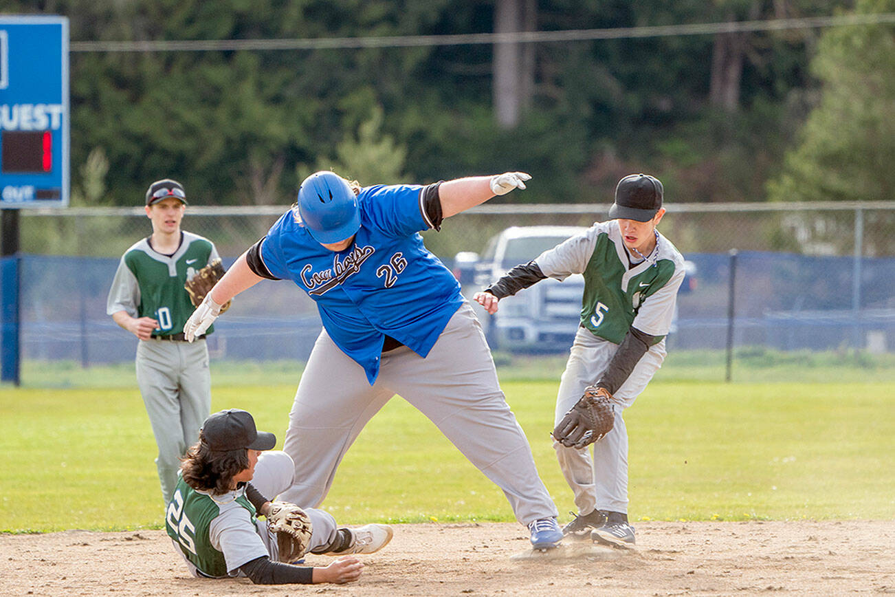 Steve Mullensky/for Peninsula Daily News

East Jefferson Rival Chris Fair maintains his balance on 2nd base so as to not get tagged out by Charles Wright’s Brandon Bennett, who has the ball in his hand, during a game in Chimacum on Wednesday. Charles Wright’s Cory Mallrie, 10, and Cole Caalim, %, are backing up the play.