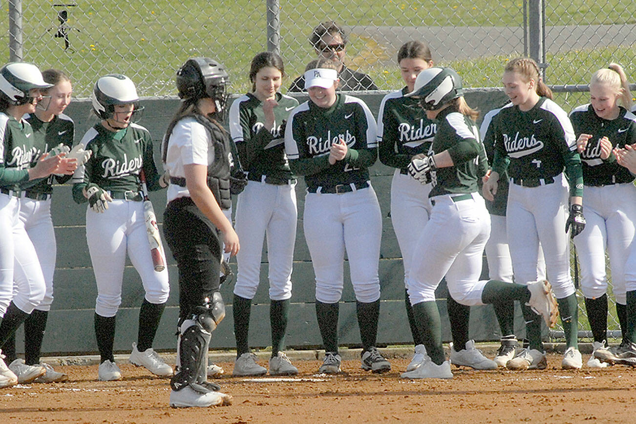 Keith Thorpe/Peninsula Daiulty News
Port Angeles' Lily Halberg, right center, is greeted by her teammates as she crosses home plate after a solo home run, the second of the first inning while Kingston catcher Audrey Rienstra looks on during Thursday's game in Port Angeles.