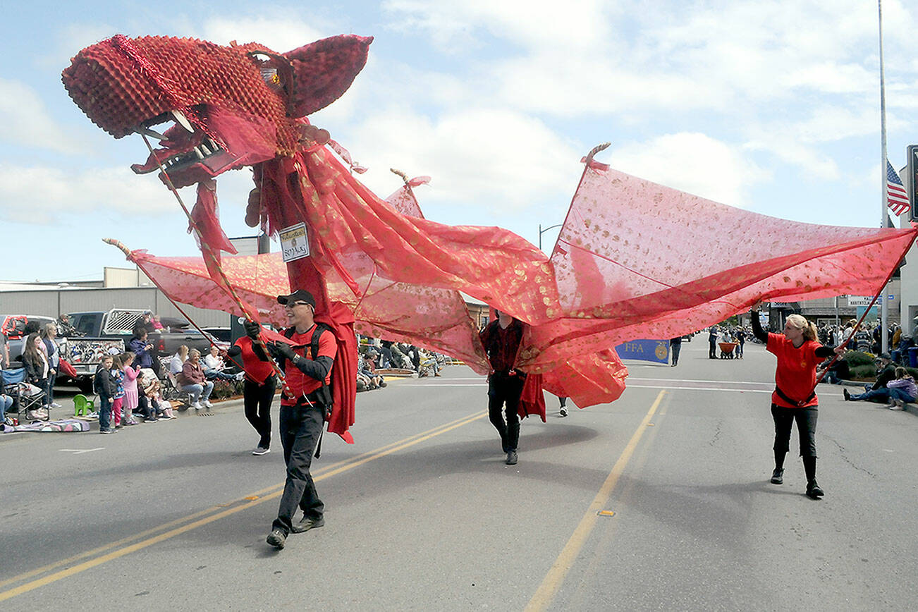 A stylized dragon with its mouth operated by Kurt White makes its way down Washington Street as part of the Olympic Theatre Arts entry in Saturday’s Sequim Irrigation Festival Grand Parade. The event returned to an in-person activity with more than 90 entries and thousands of spectators lining the parade route. (Keith Thorpe/Peninsula Daily News)