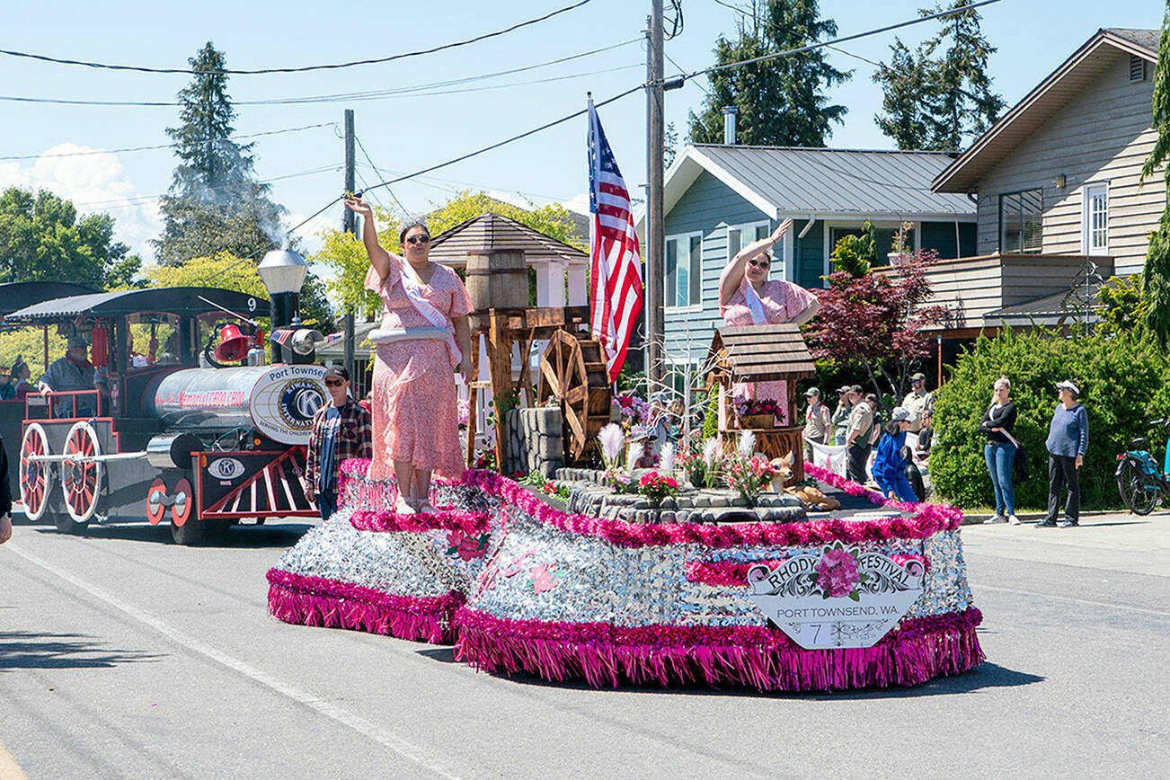 The 86th Rhody Festival float, with Princesses Brigette Palmer, left, and Hailey Hirschel waving to the crowd as they go along Lawrence Street in the Uptown neighborhood of Port Townsend. (Steve Mullensky/for Peninsula Daily News)