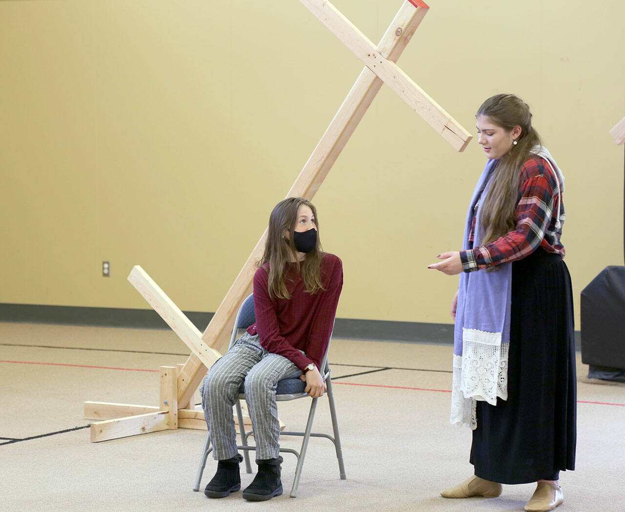 Kaylee R. Klebanow, seated, playing Miranda, looks up at Brianna Palenik, playing Prospera, during rehearsals of ‘The Tempest.’