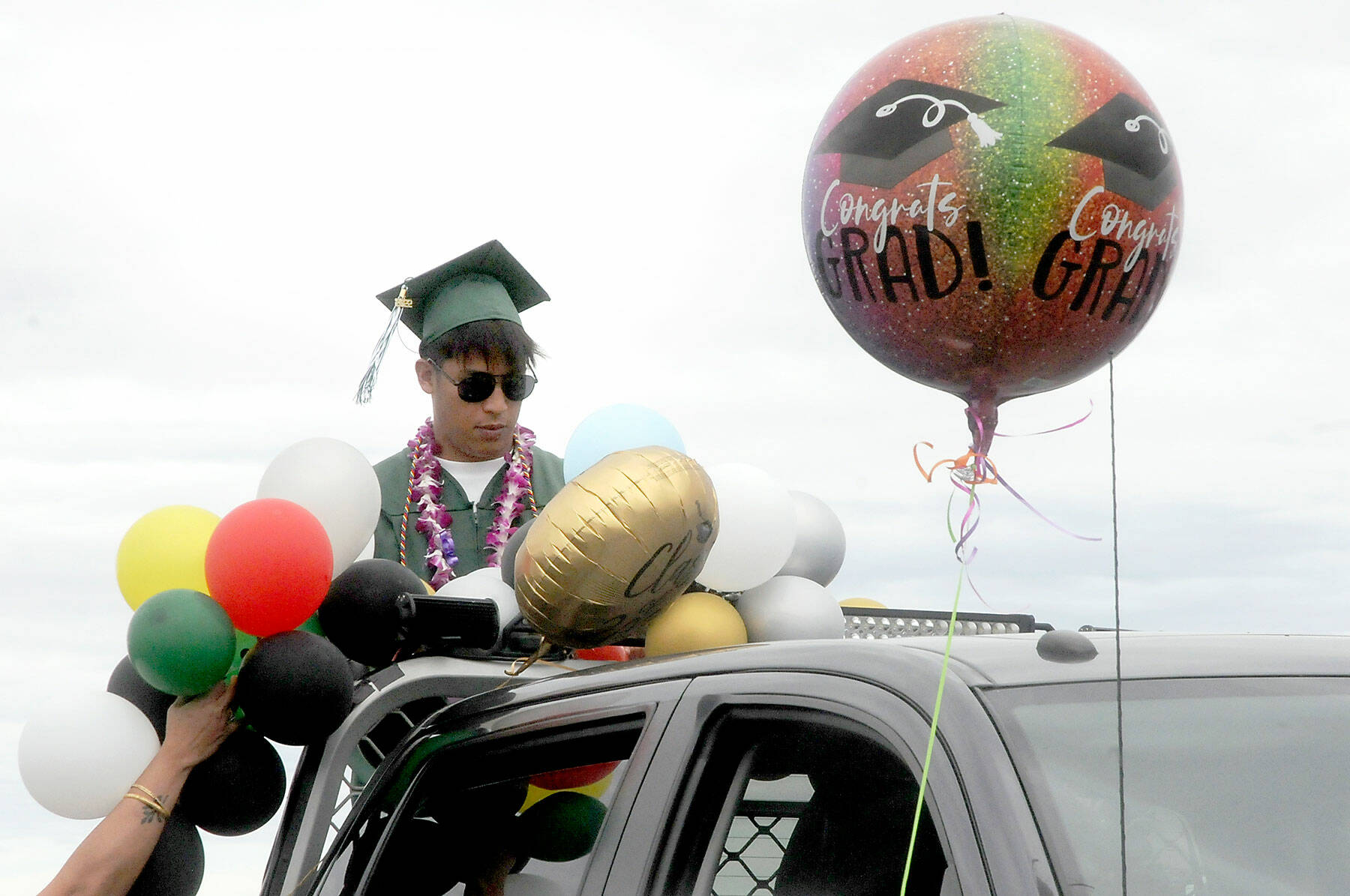 Port Angeles High School graduate Lance Menes decorates a truck that will transport him during Friday’s graduation parade from Ediz Hook to Port Angeles High School. (Keith Thorpe/Peninsula Daily News)