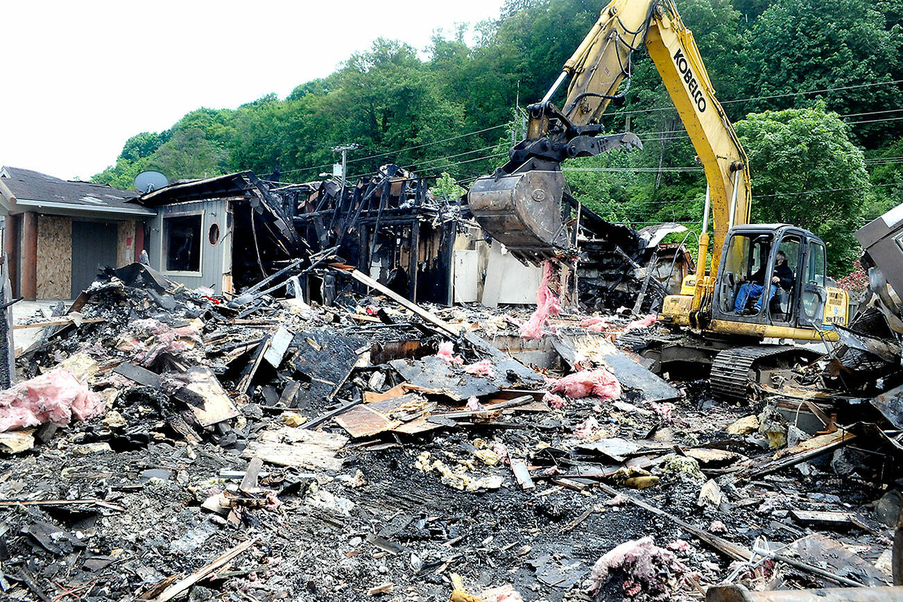 Keith Thorpe/Peninsula Daily News
An excavator pulls apart the charred wreckage of the former Castaways Restaurant and Lounge on Thursday in Port Angeles. The resaturant, located at 1213 Marine Drive at Boat Haven West,  was destroyed by a fire of unknown origin on Jan. 31. Jim Bishop Excavating is performing the demolition.