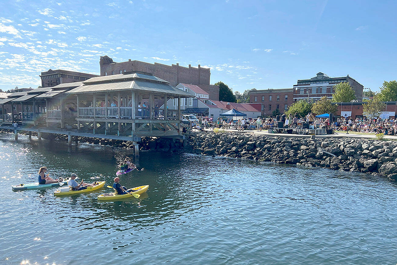 Steve Mullensky/for Peninsula Daily News

Kayakers find a cool way to beat the heat and listen to live music during Thursday’s Concert on the Dock at Pope Marine Park in Port Townsend. Another concert is set this coming Thursday when temperatures are expected to have dipped to temperatures more commonly felt on the North Olympic Peninsula.