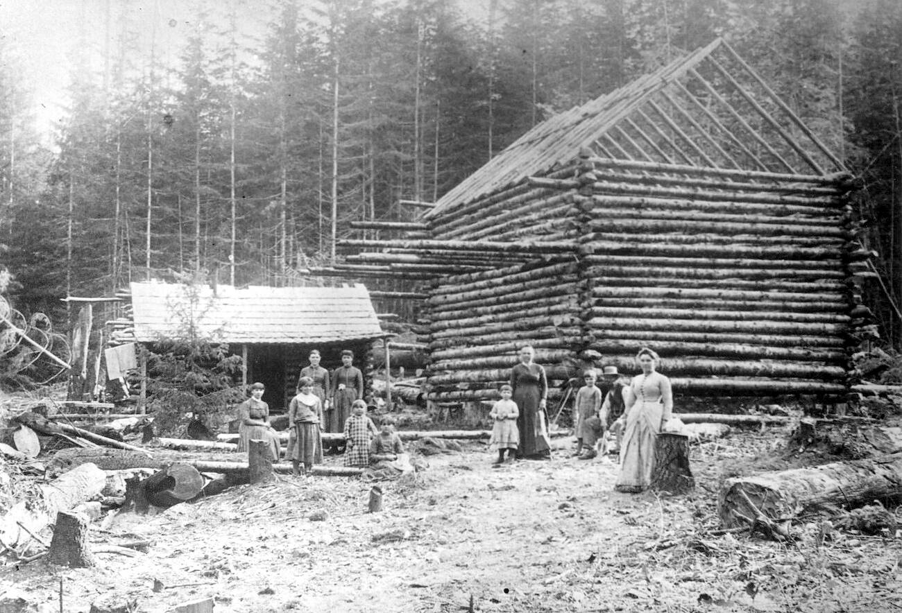 North Olympic History Center

A two story log cabin being built.  One man, four women and five children (Unidentified) are shown.  A smaller log cabin is beside the cabin under construction.