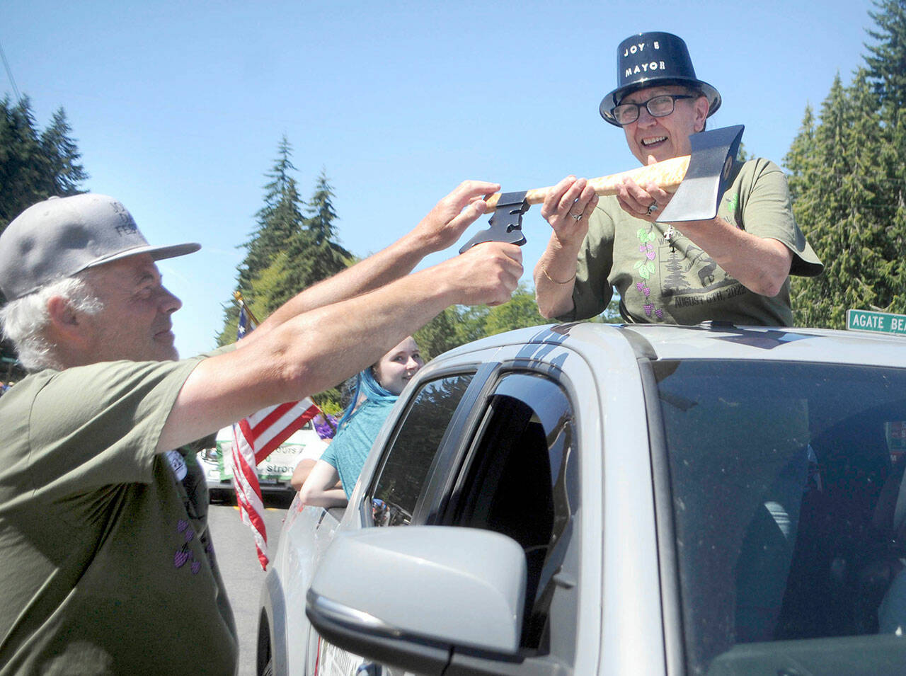 Joyce Daze Wild Blackberry Festival chairman John Kent, right, presents a “key to the city” — an ax with a key-shaped attachment — to Blackberry Cafe owner Roxanne Olsen, who was named honorary mayor of the unincorporated community during Saturday’s Grand Parade. (Keith Thorpe/Peninsula Daily News)