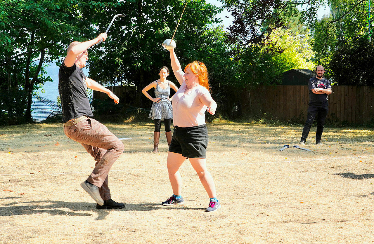 Actors Casey Bowen, left, as Paris and Emily Huntingford, right as Romeo, rehearse sword play before the opening of Key City Public Theatre’s Shakespeare in the Park production of Romeo and Juliet at Chetzemoka Park on Friday night. (Steve Mullensky/for Peninsula Daily News)