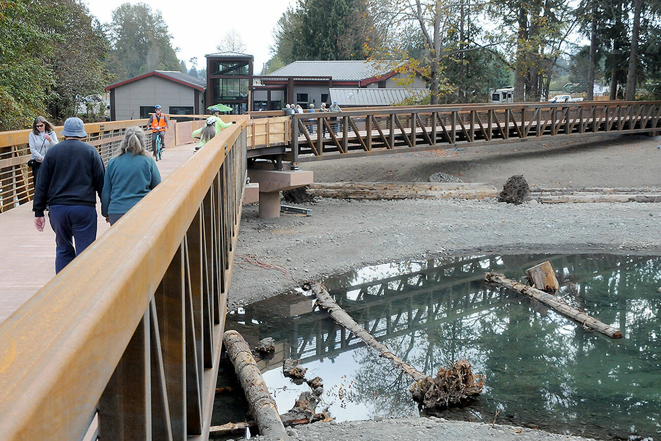 KEITH THORPE/PENINSULA DAILY NEWS
Pedestrians and bicyclists make their way arcoss a pair of new spans crossing the newly-restored flood plain of the Dungeness River at Railroad Bridge Park on Wednesday. The two spans, which opened this week, eliminate a long detour for users of the Olympic Discovery Trail by restoring the link across the river. An additional walkway, which is still under construction with an opening scheduled for later this fall, will link the trail to the outdoor patio of the recently-opened Dungeness River Nature Center.