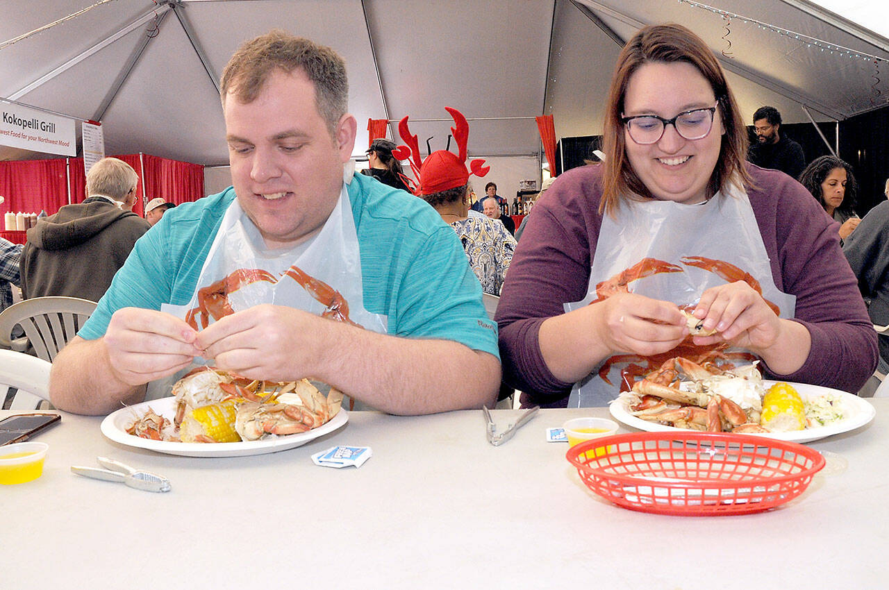 Daniel and Katherine Safarik of Wichita, Kan., enjoy a crab dinner in the dining tent on Friday at the Dungeness Crab and Seafood Festival near the Port Angeles waterfront. (KEITH THORPE/PENINSULA DAILY NEWS)