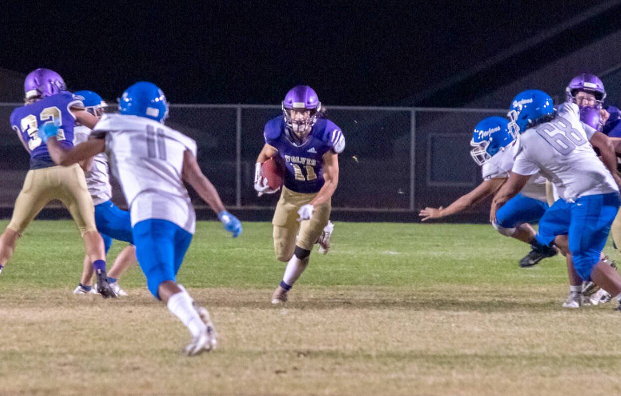 Sequim’s Aiden Gockerell runs through a big hole against Olympic on Friday night in Sequim. (Emily Matthiessen/Olympic Peninsula News Group)