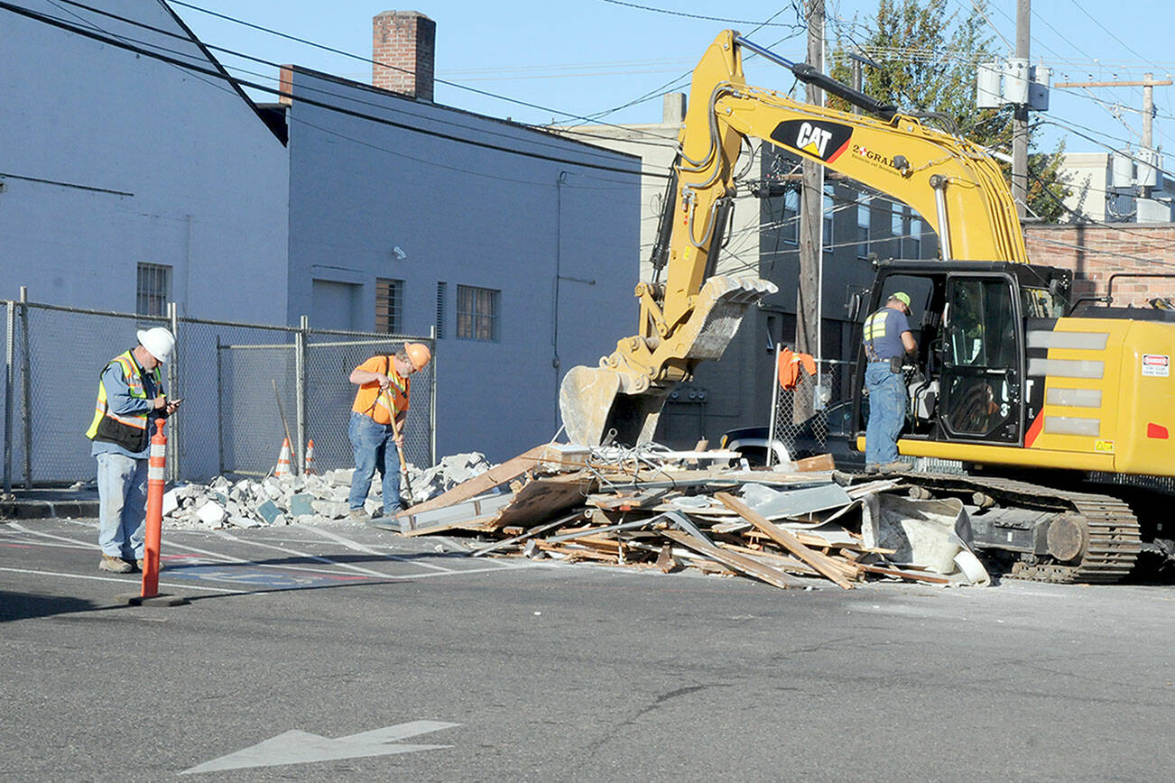 KEITH THORPE/PENINSULA DAILY NEWS
A construction crew last week goes over the remains of an aging public restroom in the parking lot between First and Front streets in the 100 block in downtown Port Angeles after it was demolished.