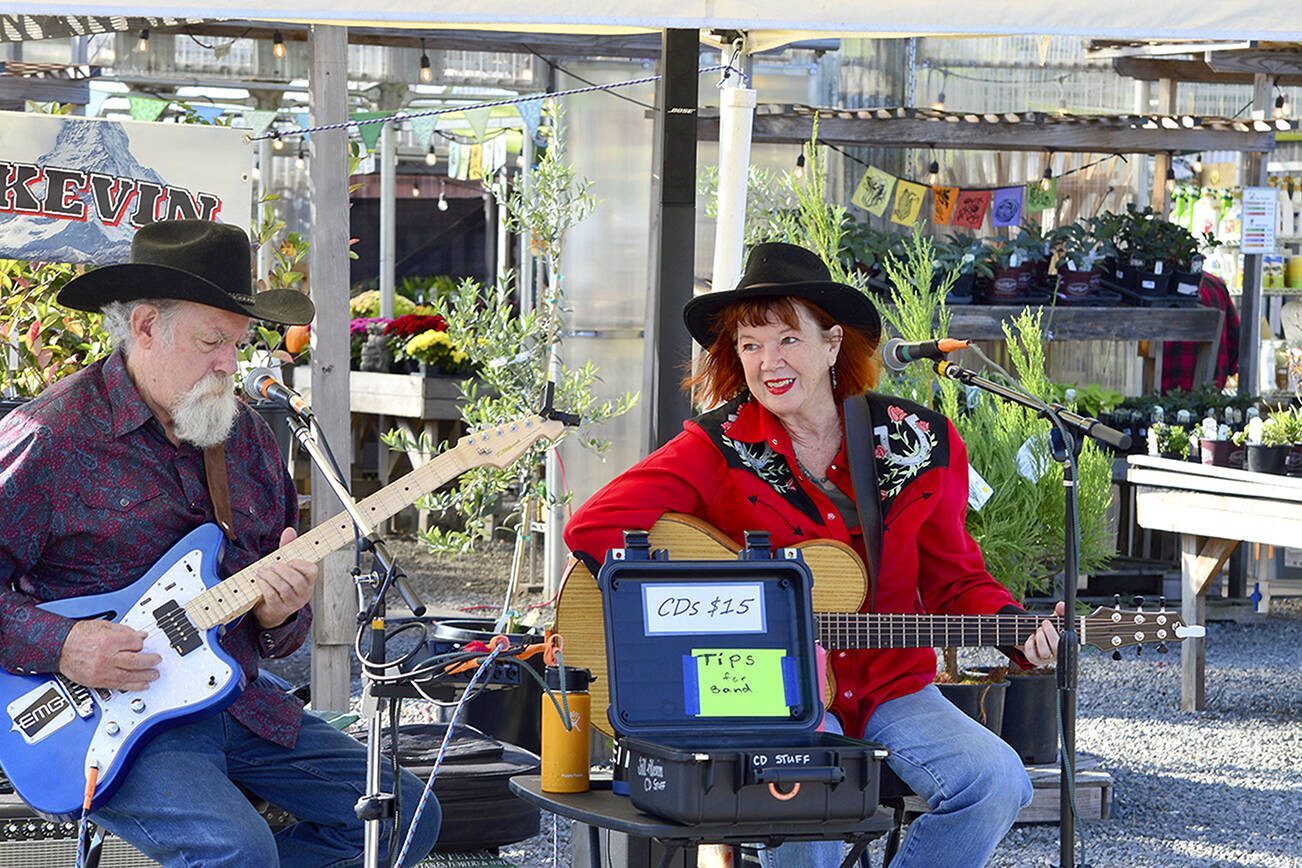 At the Sunday Chimacum Farmers Market, Jill and Kevin — aka Jill McAnally and Kevin McConell — sing country, swing and blues songs to vendors and shoppers. The produce and artisan market, outside the Chimacum Corner at 9122 Rhody Drive, will be held just two more Sundays before it wraps up for the season on Oct. 30. (Diane Urbani de la Paz/For Peninsula Daily News)