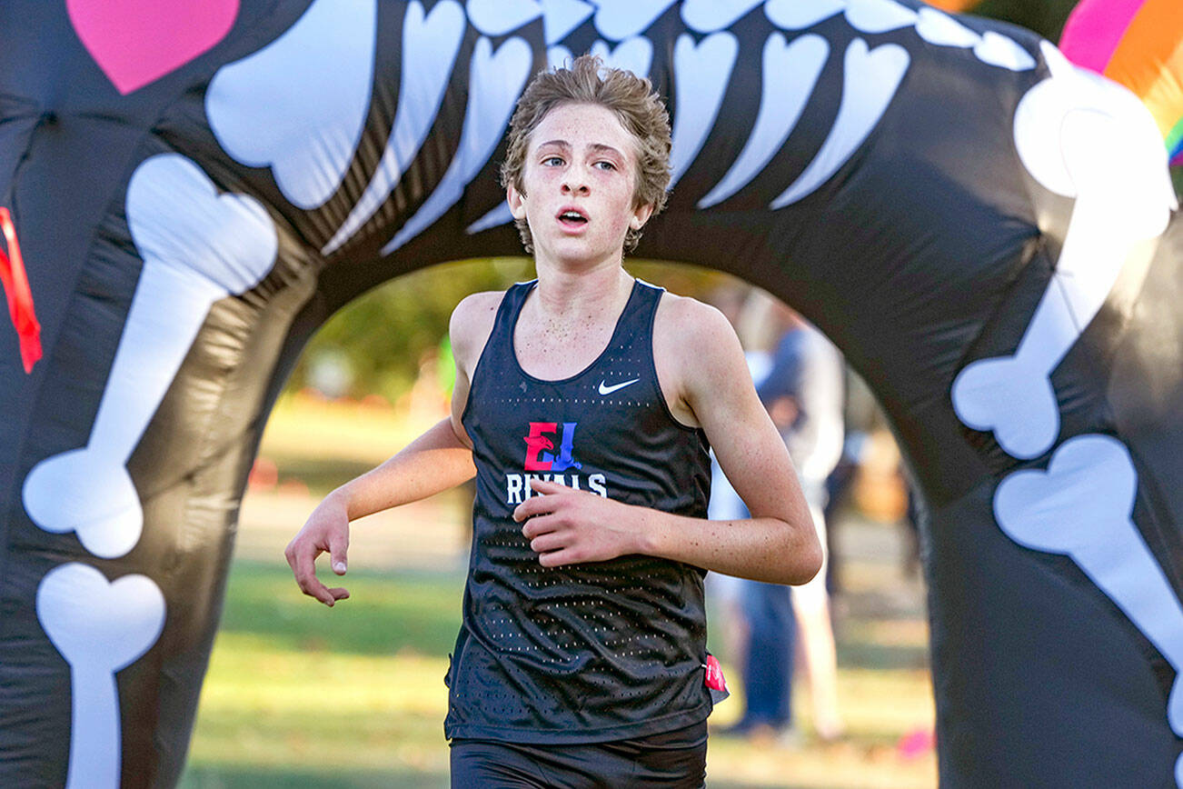 Steve Mullensky/for Peninsula Daily News

East Jefferson Rival Soare Johnston crosses under the inflatable unicorn finish line to win the Boy’s 5,000 meter Cross Country race on Tuesday at Port Townsend Golf Course.