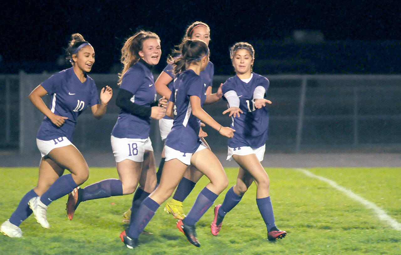 Michael Dashiell/Olympic Peninsula News Group Sequim teammates, from left, Jenny Gomez, Jenna Mason, Hailey Wagner (obscured) and Aliyah Weber celebrate Raimey Brewer, front, after her early goal put the Wolves up 1-0 on Kingston on Thursday.