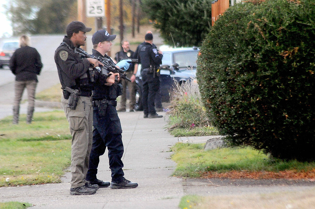 Armed police keep watch on an alley between Fifth and Sixth streets at Oak Street in Port Angeles after a report of shooting from a house in the 200 block of West Sixth Street on Tuesday. (Keith Thorpe/Peninsula Daily News)