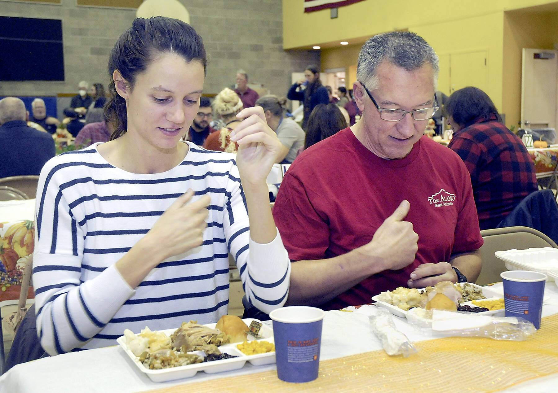 KEITH THORPE/PENINSULA DAILY NEWS
Cecilia Stevenson, of Dallas, left, and her father, Will Stevenson of Port Angeles, say a blessing before enjoying a Thanksgiving meal in the fellowship hall of Queen of Angeles Catholic Church in Port Angeles. The church offered a traditional Thanksgiving dinner for the community, with several hundred diners taking advantage of the in-house meal. Numerous other dinners were sent out for in-home dining.