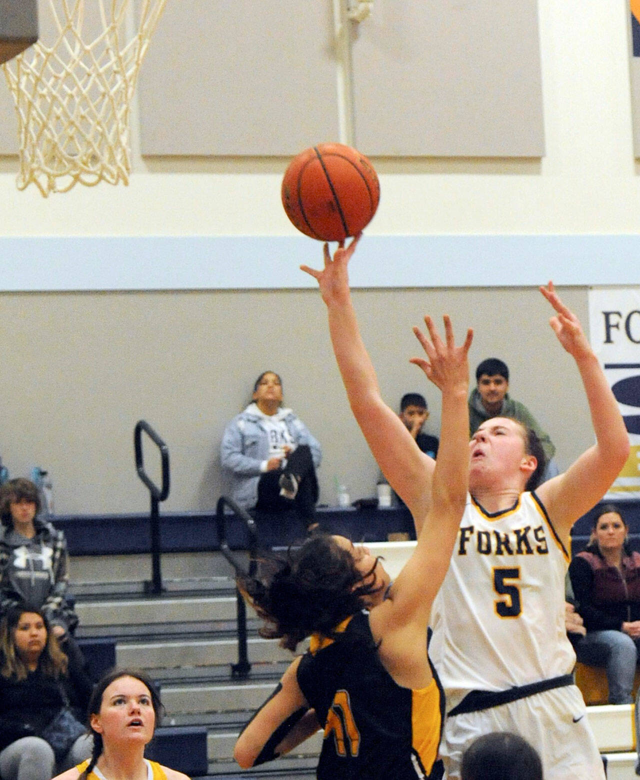 Lonnie Archibald/for Peninsula Daily News Forks’ Keira Johnson scores over North Beach’s Malia Cox in Forks on Wednesday evening where Forks defeated North Beach 59-15.