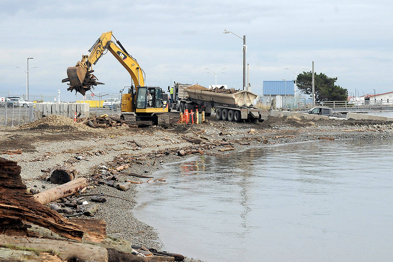 KEITH THORPE/PENINSULA DAILY NEWS
An excavator picks up woody debris for loading onto a nearby truck for disposal on Tuesday at the site of the former aquaculture site near the boat ramp on Ediz Hook in Port Angeles. The Ediz Hook Shoreline Restoration project, conducted by Western Marine Construction, Inc. in conjunction with the Navy Facilities Engineering Systems Command (NAVFAC) Northwest, is designed to return a section of shoreling on the harborside section of the hook to its former condition with the removal of an area formerly used for maintining fish pens in Port Angeles Harbor.