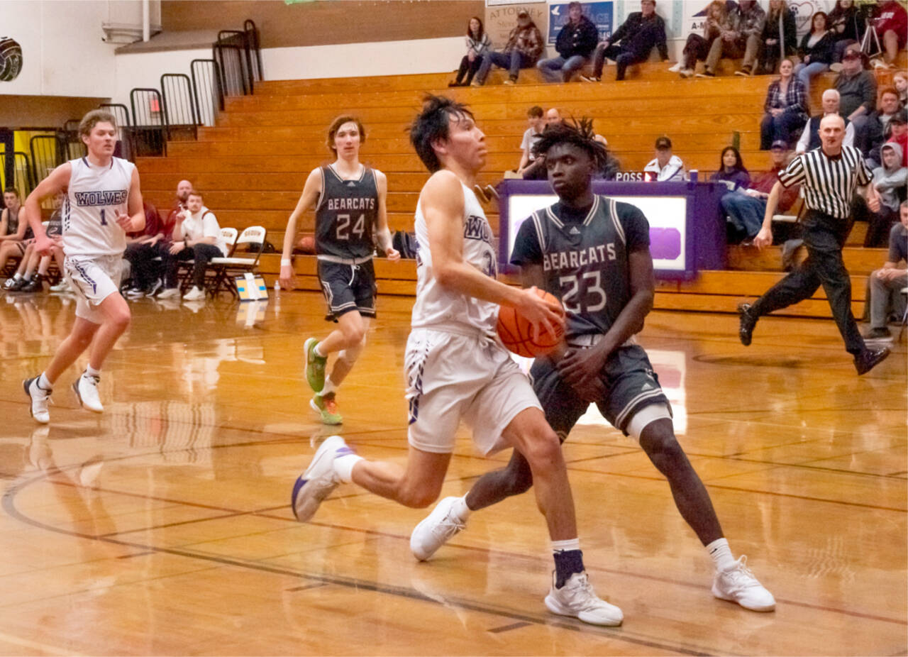 Sequim’s Isaiah Moore drives to the basket around the defense of WF West’s Brian Anouma (23). Also in the play are Sequim’s Zach Thompson (1) and WF West’s Tyler Klatush (24). (Emily Matthiessen/Olympic Peninsula News Group)