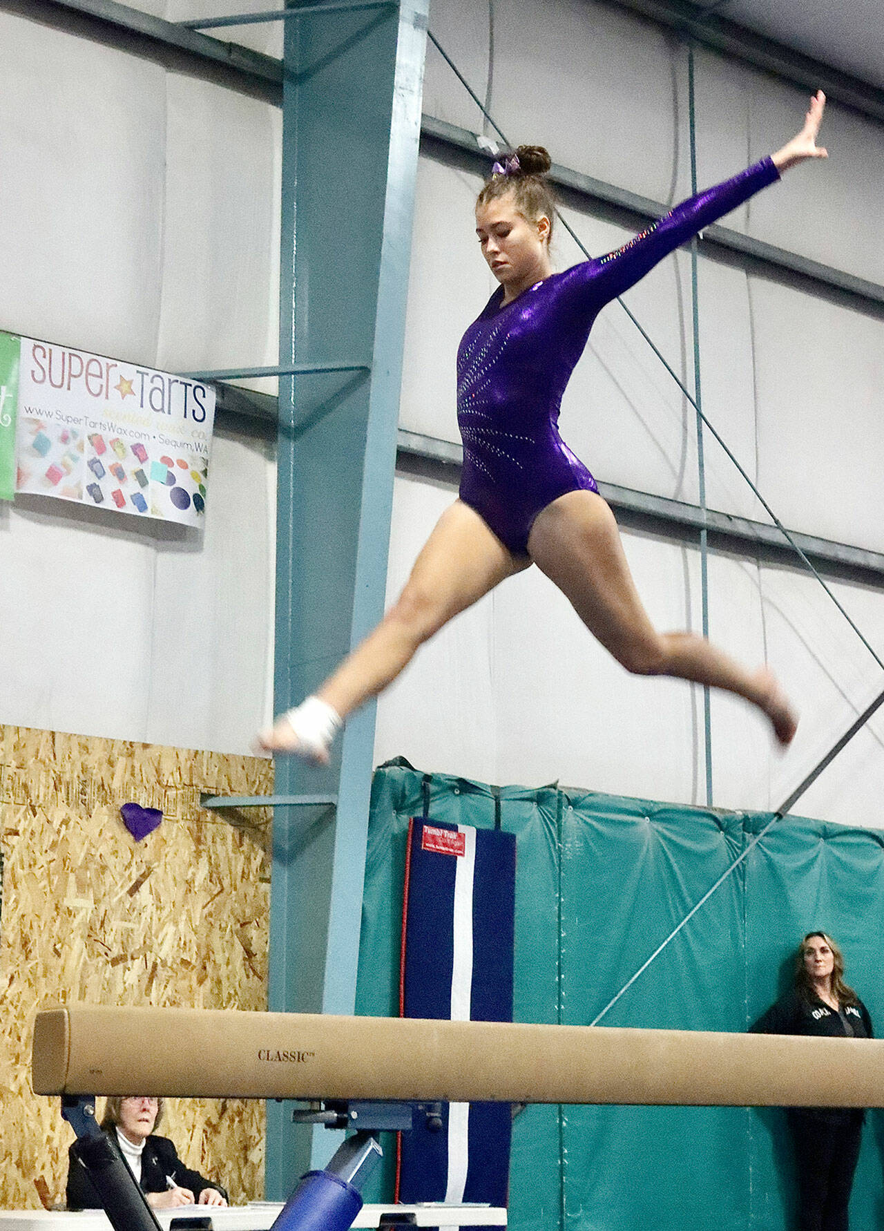 Dave Logan/for Peninsula Daily News Sequim gymnast Amara Browngirls flies high over the balance beam at the Port Angeles/Sequim-Bainbridge dual meet at Klahhane Gymnastics on Wednesday.