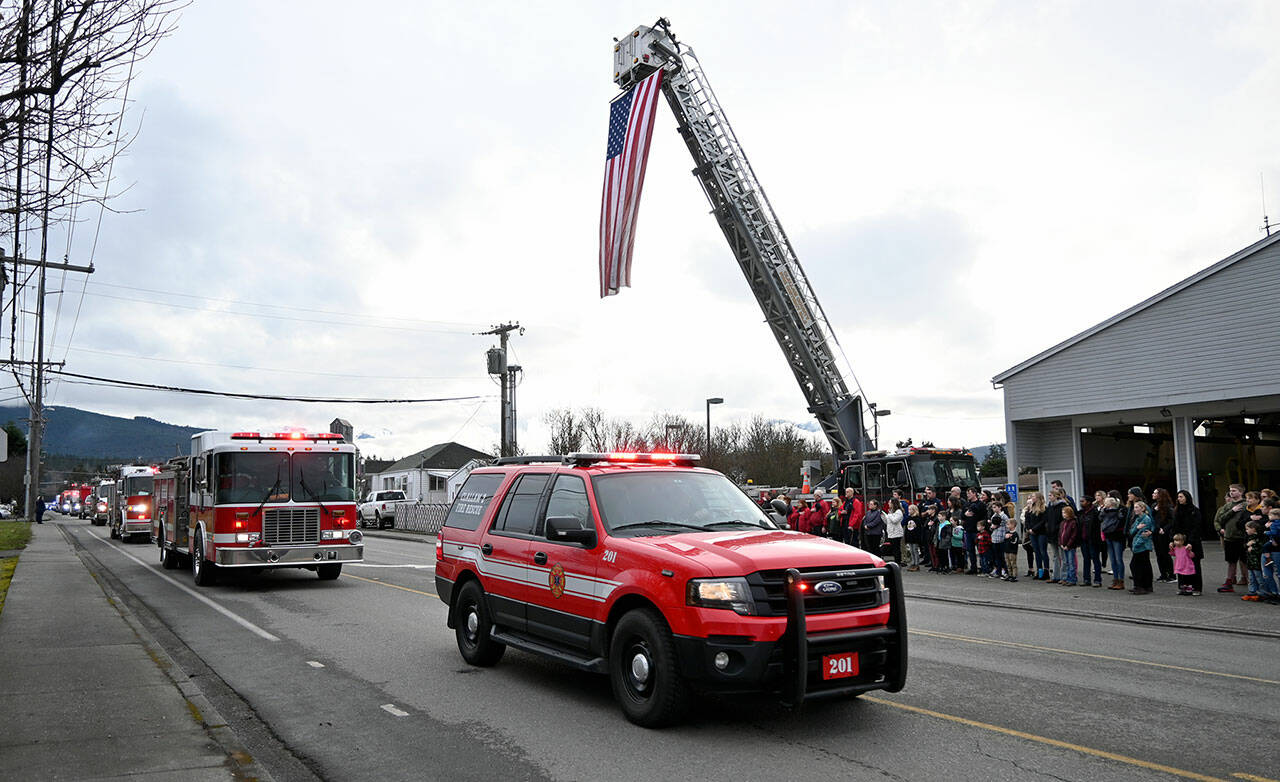 Staffers from Clallam County Fire District 3 in Sequim, other North Olympic Peninsula fire departments and first responders honor Fire District 3 Capt. Charles “Chad” Cate with a procession of vehicles through Sequim on Friday. (Michael Dashiell/Olympic Peninsula News Group)