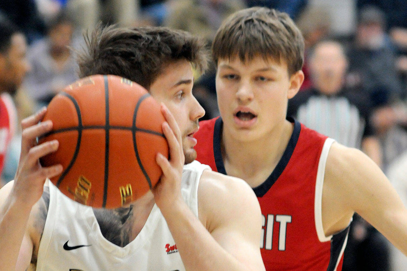 KEITH THORPE/PENINSULA DAILY NEWS
Peninsula's Max D'Amato, front, looks past the defense of Skagit Valley's Jacob Bilodeau on Wednesday night in Port Angeles.