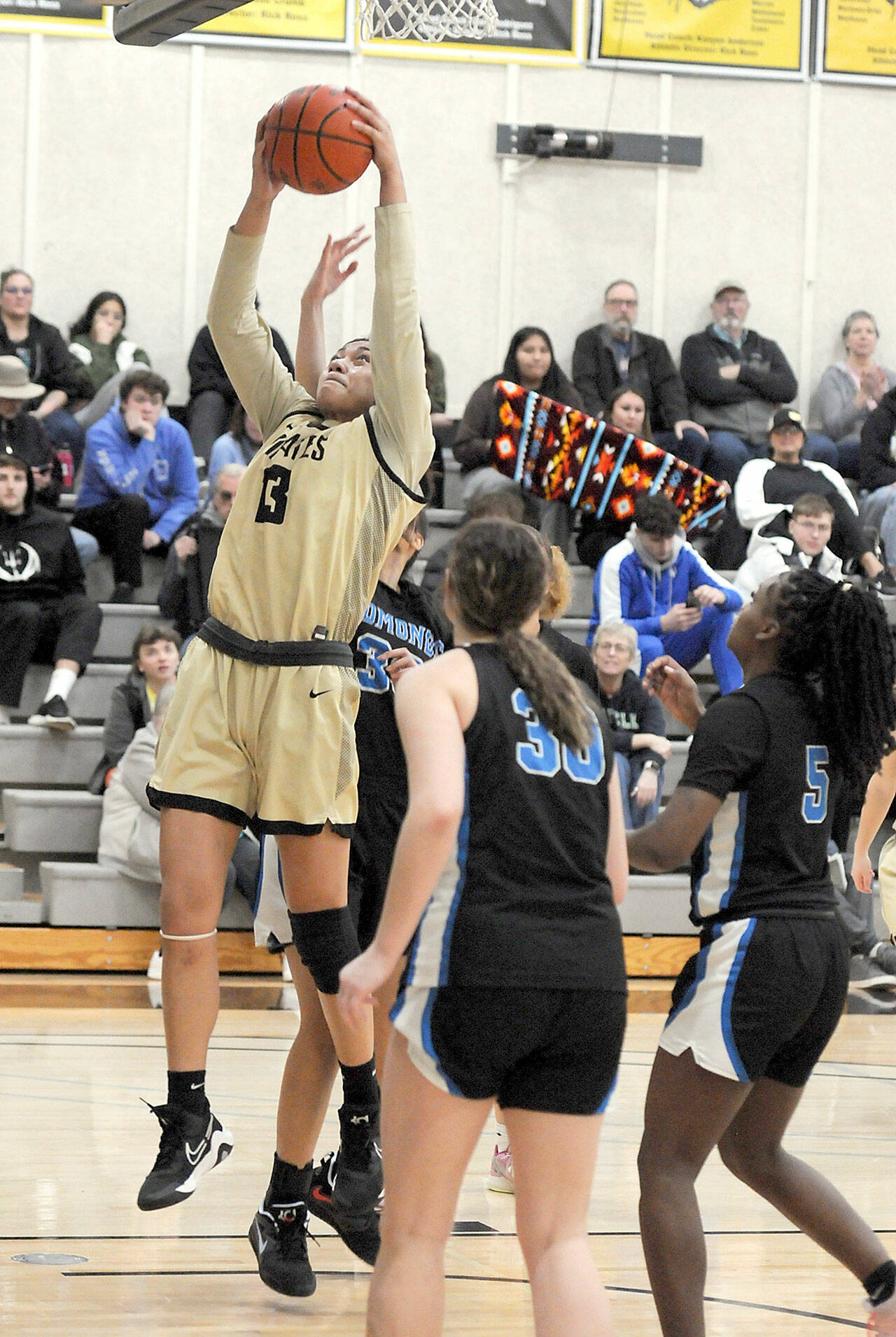 Peninsula’s Ituau Tuisaula reaches for the hoop as Edmonds defenders, from left, Leilani Motta, Aspen Carter and Danielle Woods look on during Saturday’s game in Port Angeles. (Keith Thorpe/Peninsula Daily News)