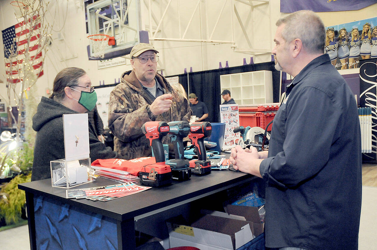 Jack and Marcella Ridge of Sequim talk about power tools with Tony Contestable, tool specialist with Hartnagel Building Supply of Port Angeles, right, during Saturday’s 2023 Building, Remodeling & Energy Expo in the Sequim High School gym. The two-day event, hosted by the North Peninsula Building Association, featured a variety of booths, displays and presentations dedicated to home building, repair and remodeling. (Keith Thorpe/Peninsula Daily News)