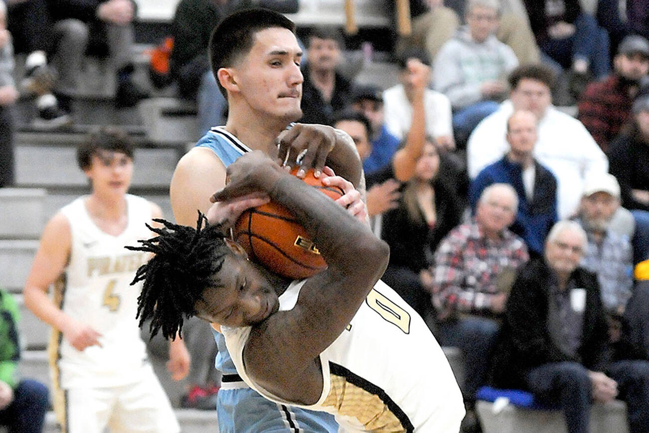 Keith Thorpe/Peninsula Daily News
Peninsula's Ese Onakpoma tries to avoid getting the ball wrestled away by Whatcom's Chase Calvin on Wednesday in Port Angeles.