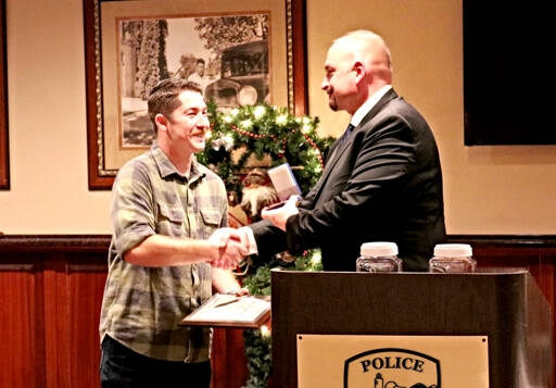 Sequim Police Officer Daniel Martinez receives a Purple Heart at a Sequim Police Department awards dinner in December 2022 from Sgt. Dave Campbell for his actions in stopping a man who allegedly attempted to kill him during a traffic stop. (Sequim Police Department)