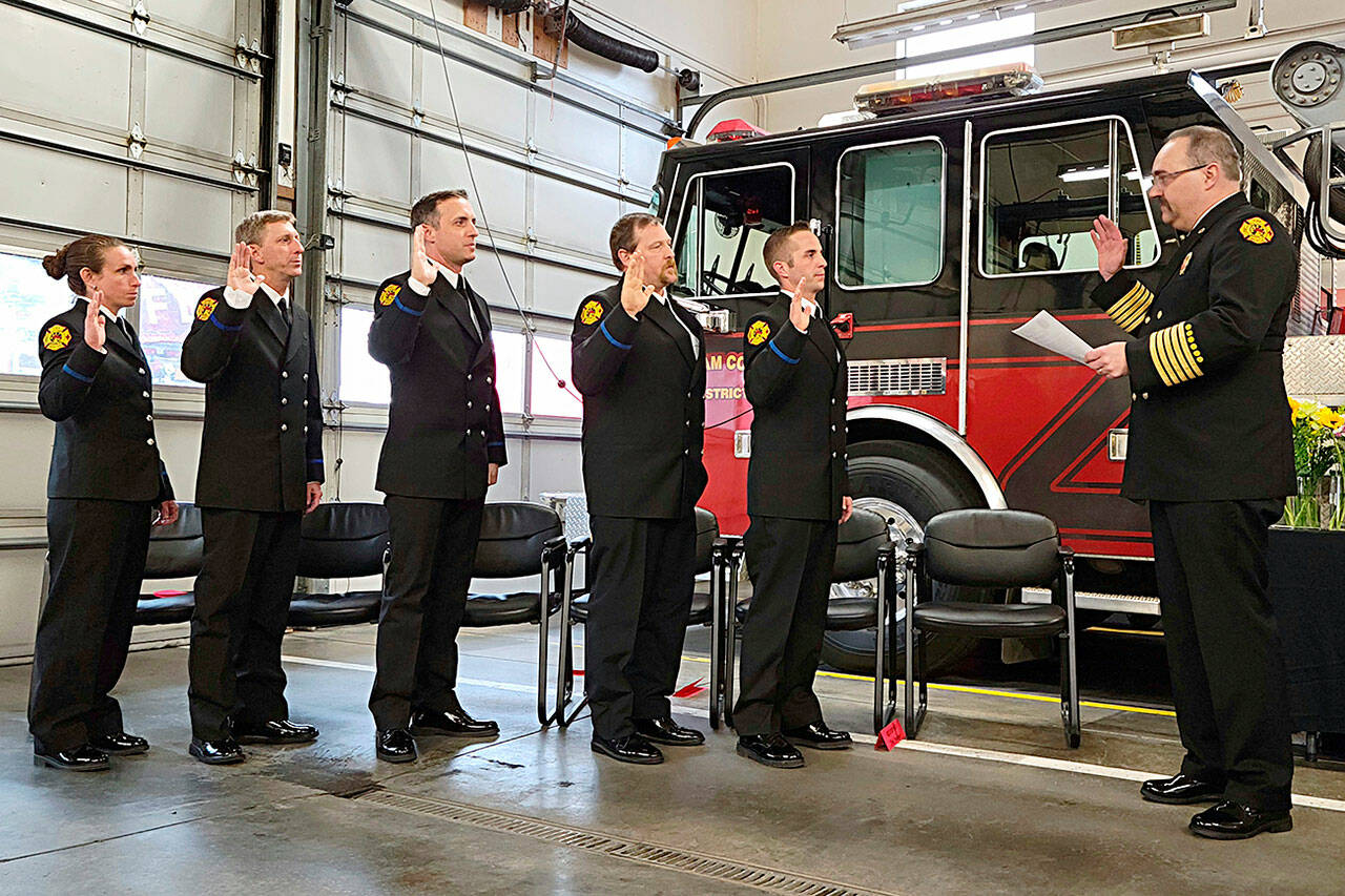 Fire chief Ben Andrews with Clallam County Fire District 3, far right, swears in probationary firefighters/paramedics, from left, Eliza Winne, Erik Payne, Bryant Kroh, Mark Karjalainen and Jeremy Church on March 20 in Station 34 for a badge-pinning ceremony. (Clallam County Fire District 3)