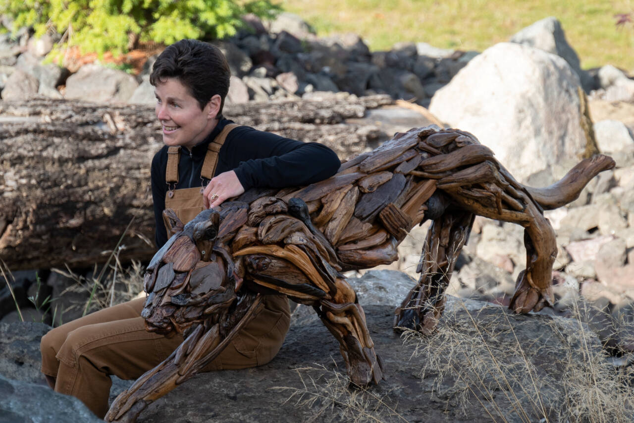 Driftwood artist Molly Omann poses with her life-sized cougar sculpture, which will be on display at Sequim Museum & Arts in April and during the First Friday Art Walk. (Molly Omann)